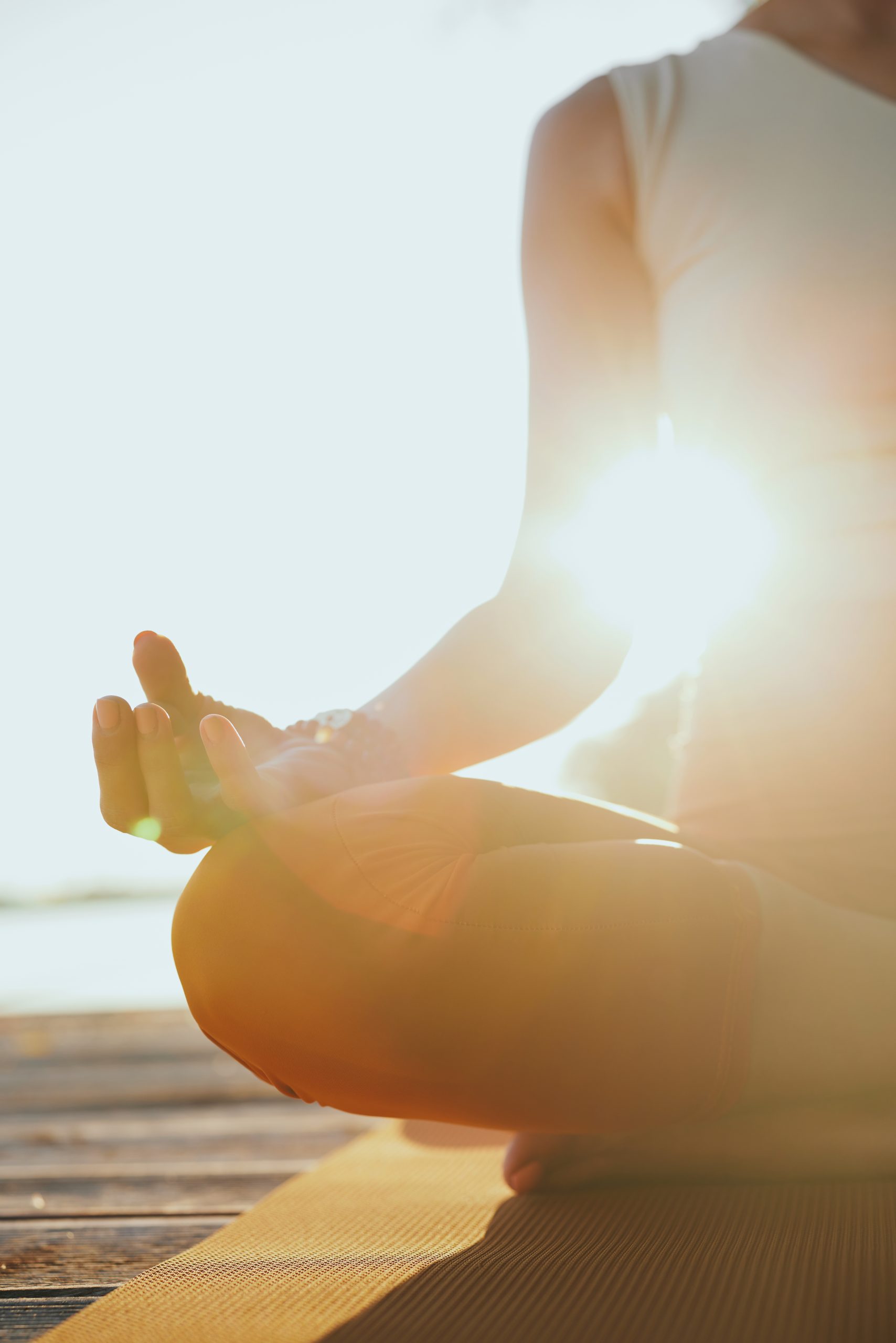 Close-up of a yogi woman sitting in a lotus pose and meditating.